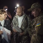Representatives of the Ukrainian government forces (C and R), and reptesentative of pro-Russian rebels (L) talks before exchanging prisoners-of-war (POWs), north of Donetsk, eastern Ukraine