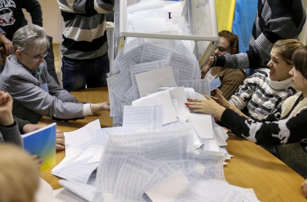 Members of a local electoral commission empty a ballot box at a polling station after voting day in Kiev
